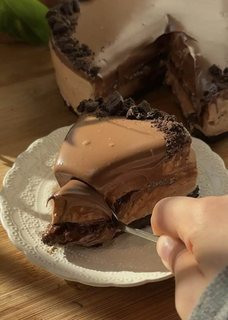 Spoon digging into creamy no-bake Nutella cheesecake.