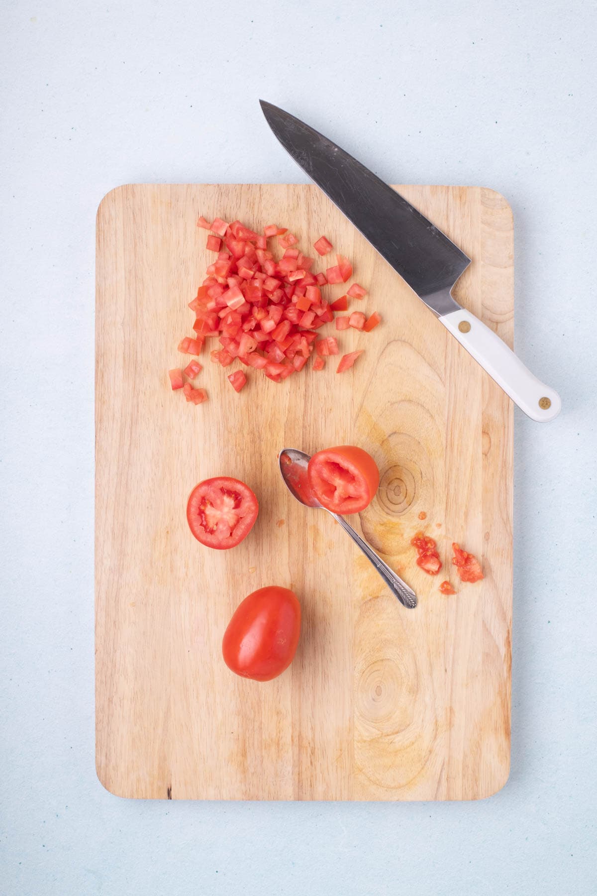 Seeded and diced Roma tomatoes on cutting board for fresh shrimp ceviche recipe
