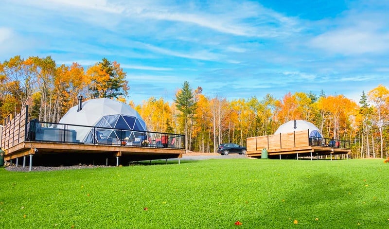 Exterior of the Valley Sky Glamping  domes, showing the decks and the forest behind. Nova Scotia glamping domes.