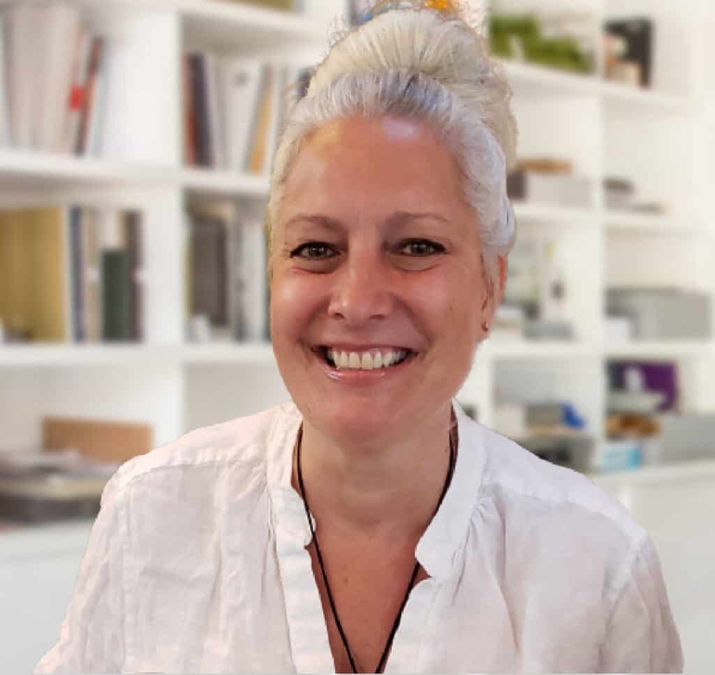 Bright smiling woman with white hair in a cozy home library setting, showcasing talent for interior design, home decor, or lifestyle photography.