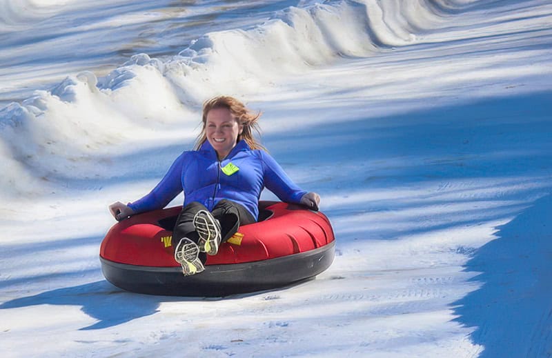 Things to do in North Carolina in winter - a young lady snow tubing at Jonas Ridge Snow Tubing Park.