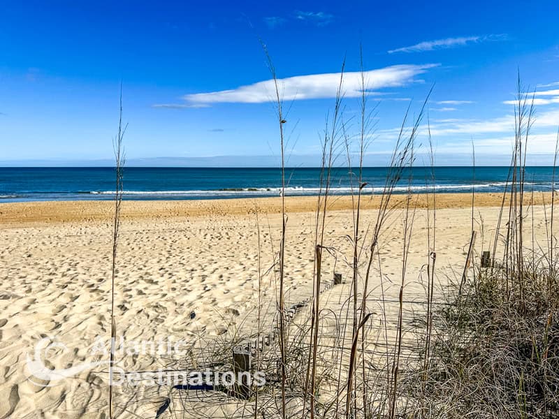 Scenic beach scene featuring golden sand, gentle ocean waves, and clear blue sky, perfect for relaxing seaside vacations and coastal getaways.