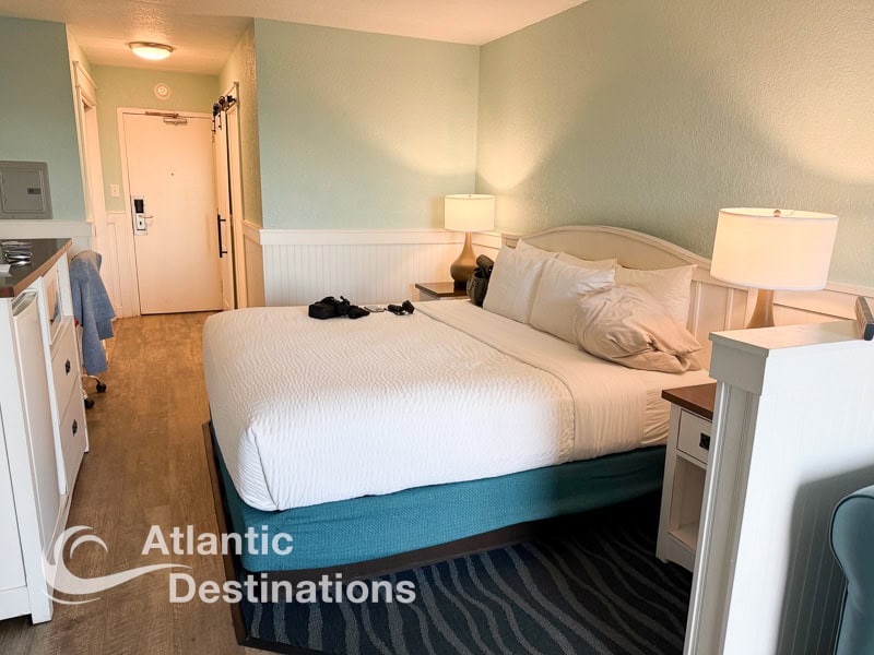 Comfortable hotel room featuring a large bed, soft lighting, and modern furnishings, perfect for a relaxing stay at Atlantic Destinations.