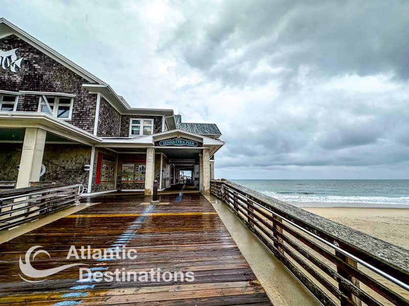 Scenic view of the beachfront boardwalk at Atlantic Destinations Resort with a wooden walkway, ocean waves, and a cloudy sky, perfect for seaside vacation photos.