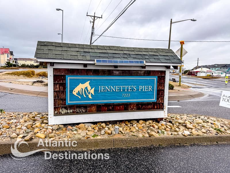 Jennette's Pier signboard at the entrance, featuring a fish logo and the pier's name, located in North Carolina.