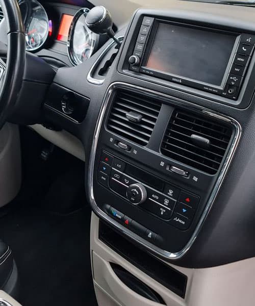 Moderner Fahrzeugzentralbildschirm und Bedienelemente im Auto-Cockpit.