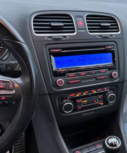 Modernes Autoradio mit digitalem Carkit und Bedienfeldern im Fahrzeug-Innenraum.