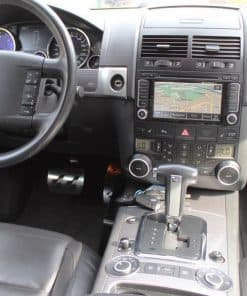 Fahrzeugarmaturenbrett mit Navigationssystem und Schalthebel.