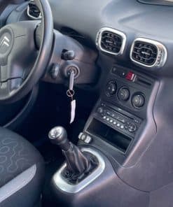 Steuerungskonsole im Autoinnenraum mit Radio- und Klimasteuerung.