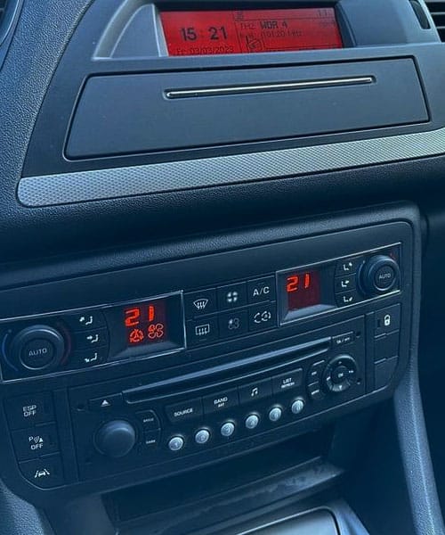 Temperaturregler und Klimaanlage im Fahrzeug, digital eingestellt auf 21°C. Zeigt Komfort und präzise Steuerung des Auto-Klimasystems.