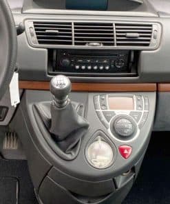 Alter Text: Innenansicht eines Auto-Dashboards mit Schalthebel und Klimasteuerung.