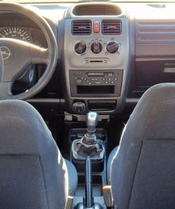 Frontansicht des Innenraums eines Autos mit manueller Schaltung, im Fokus das Armaturenbrett und die Schaltung.