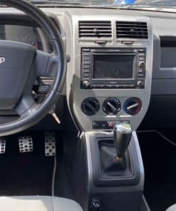 Autofront mit neuem Autoradio installiert, Übersichtliche Bedienelemente und manueller Schalthebel sichtbar.