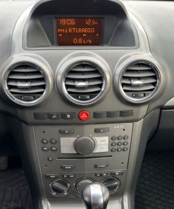 Zentraldisplay im Cockpit eines Autos zeigt Uhrzeit und Radio-Informationen.