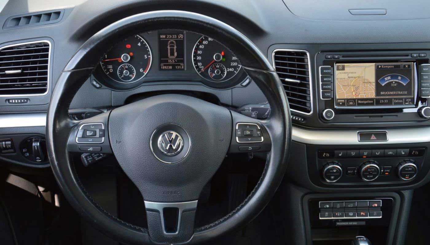 Autoarmaturenbrett mit Navigationssystem und Steuerungsknöpfen.