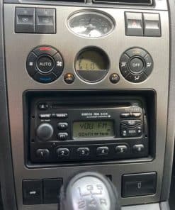 Hochwertiges Autoradio mit KFZ-Adapter und Bedienelementen im Armaturenbrett.