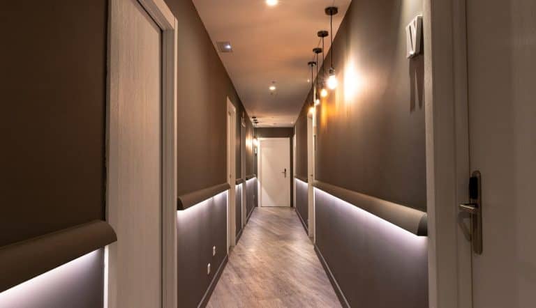 Pasillo moderno iluminado con luces colgantes y puertas