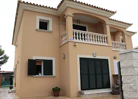 Fachada de casa moderna con terraza y ventanas verdes