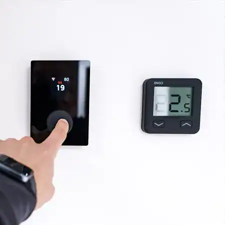 Persona ajustando termostato digital moderno