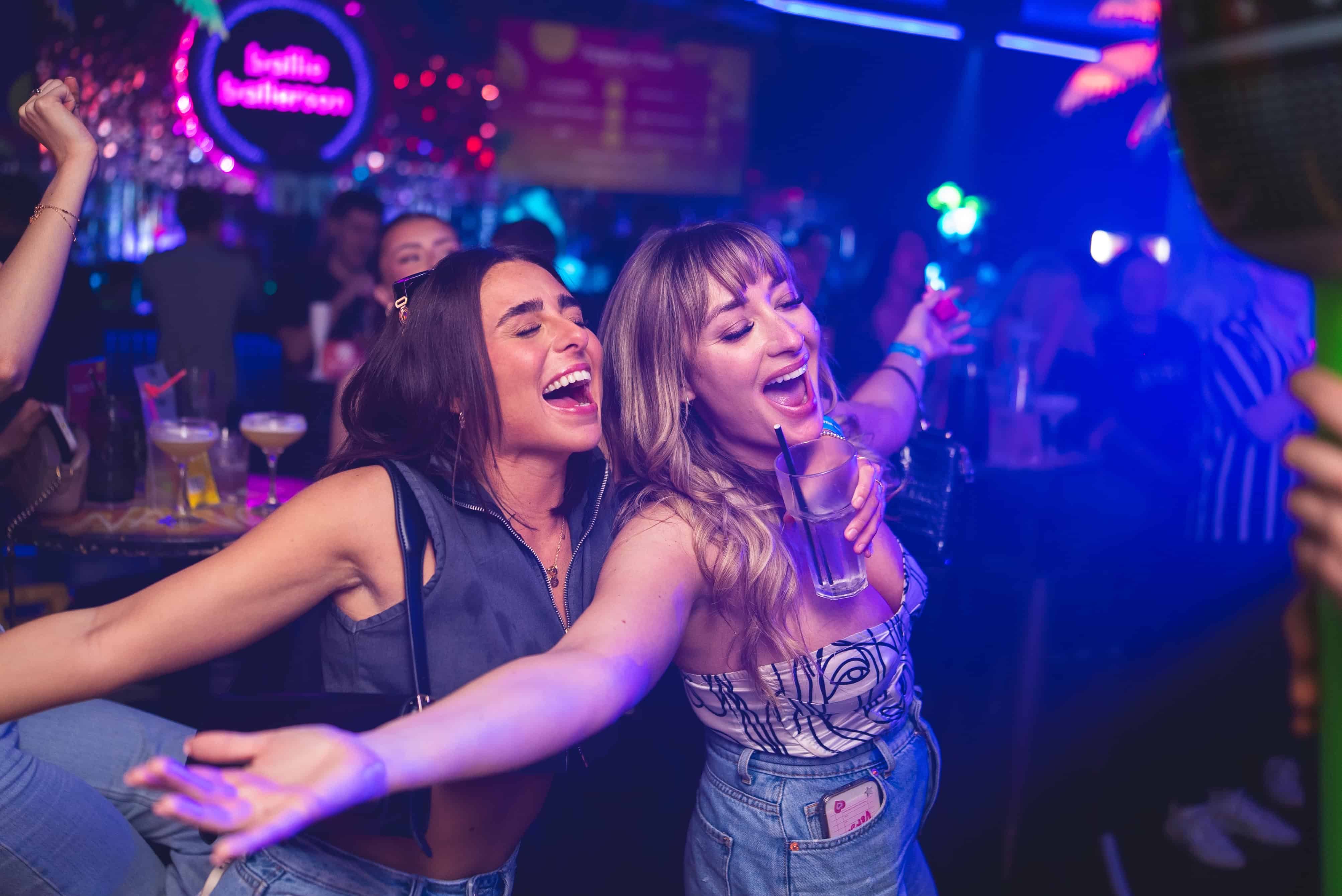 two girls eating pizza at a bottomless brunch