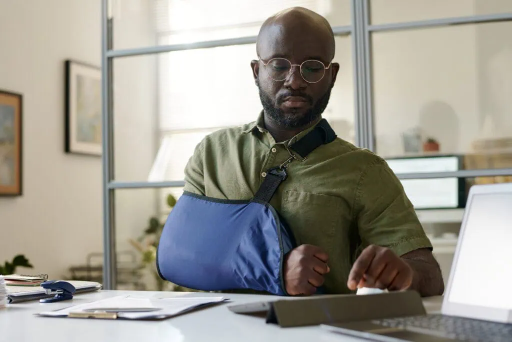 Employee with arm injury in office, using modified duties program.