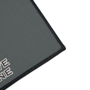 Gray doormat with black border and text design.