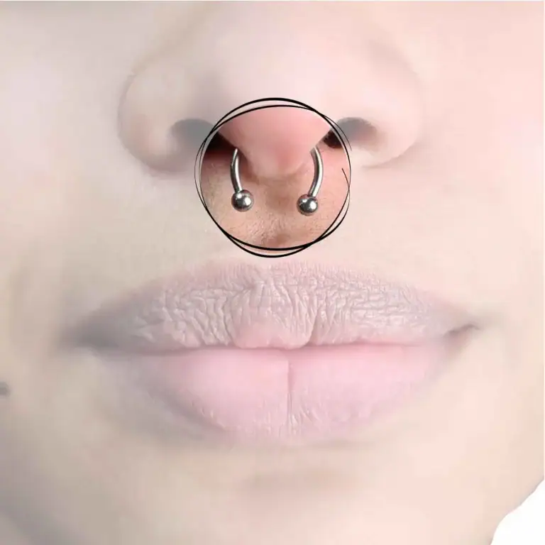 Ein markantes Septum-Piercing, zentral in der Nasenscheidewand platziert, akzentuiert mit einem eleganten Ring, der traditionellen Stil mit modernem Flair verbindet.