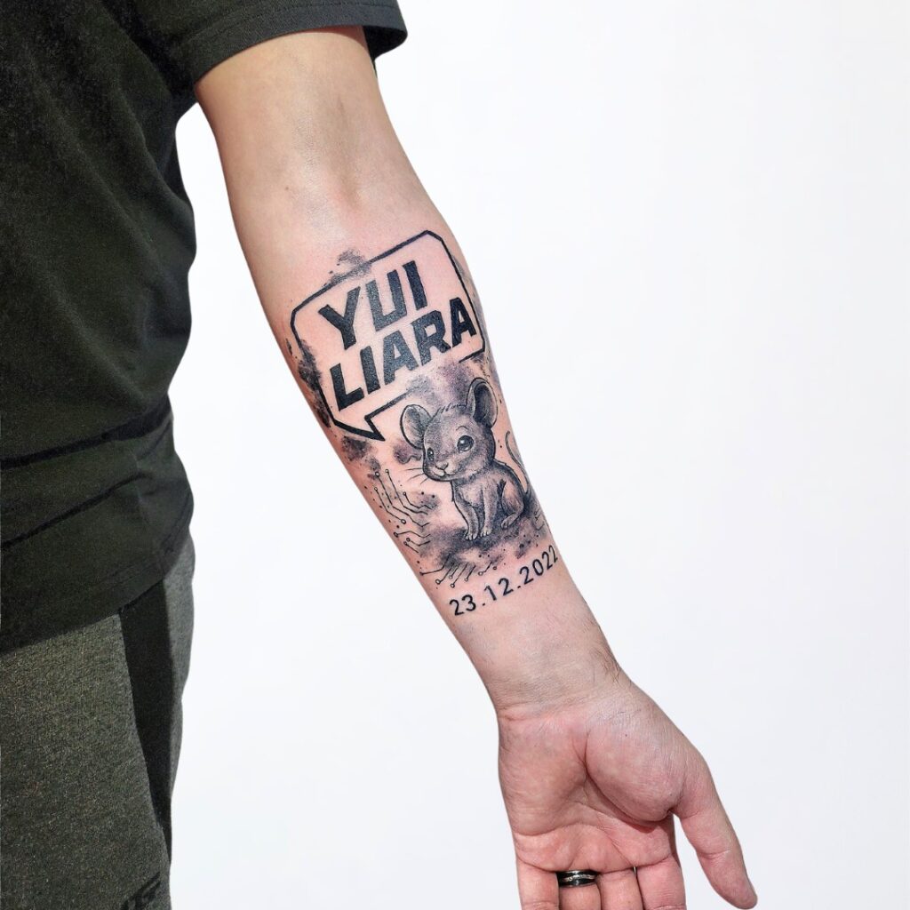 Familien Tattoo Widnau im Comic-Stil mit Name «Yui Liara» und Mausmotiv – Black & Grey Tattoo mit Geburtsdatum.