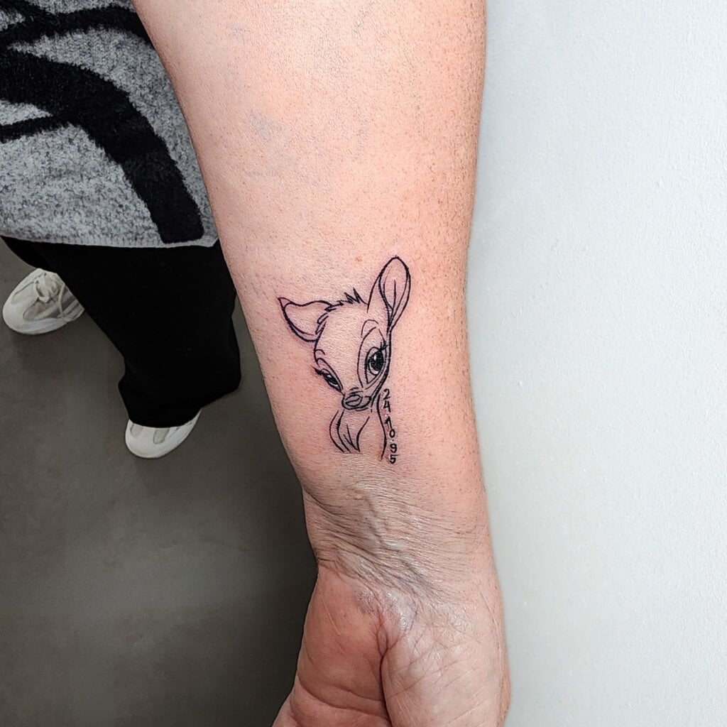 Bambi Tattoo mit feiner Linienarbeit und Datum – Familien Tattoo gestochen in Widnau.