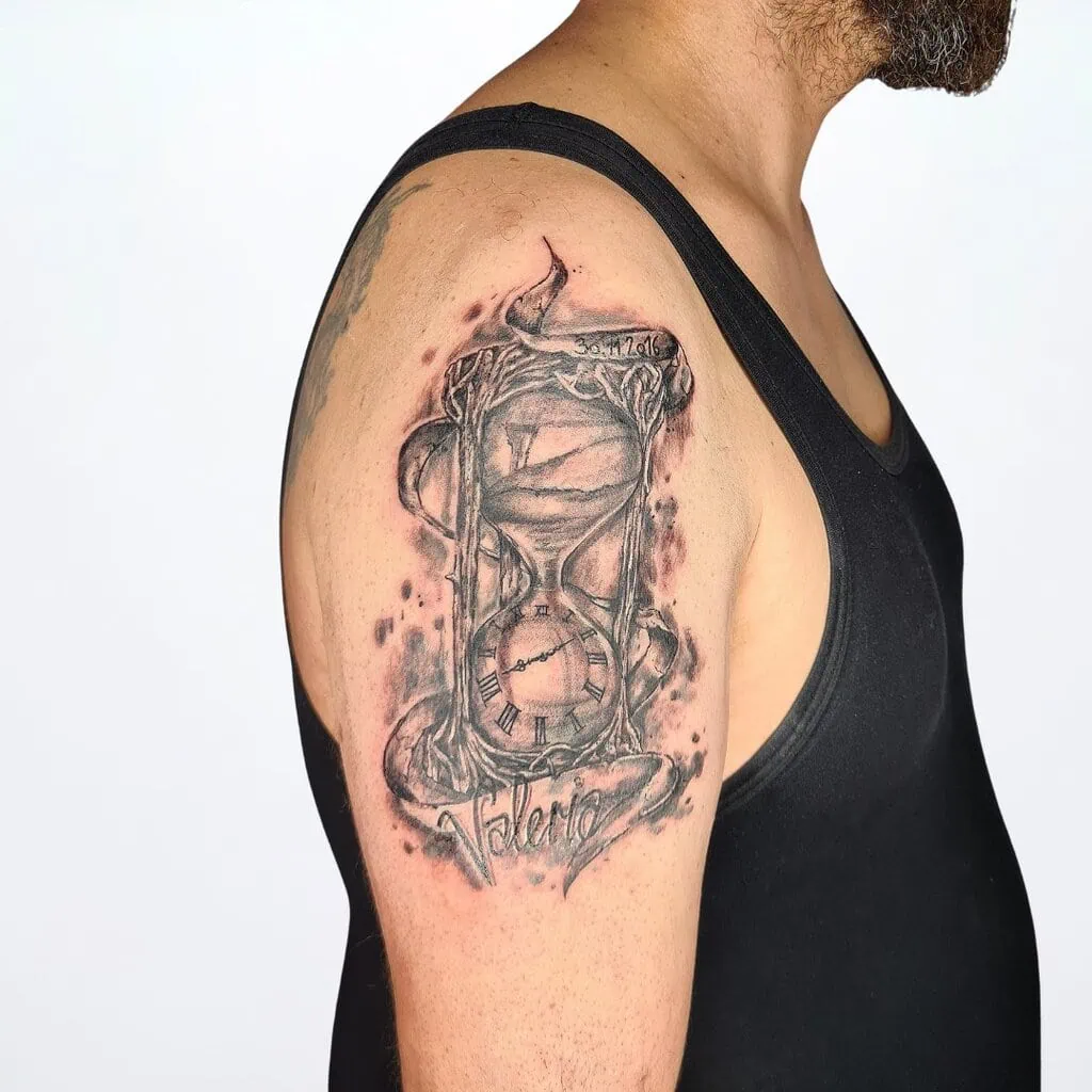 Tattoo mit Sanduhr, Wurzeln und Name «Valeria» – Black & Grey Familien Tattoo auf dem Oberarm, gestochen in Widnau.