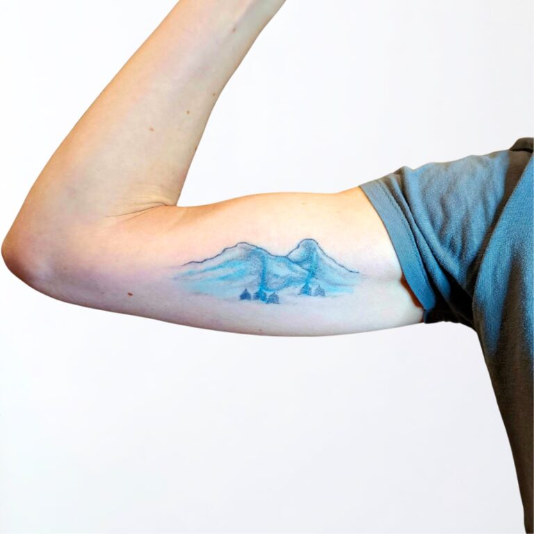Verblasstes Berg Tattoo am Oberarm – Motiv vor dem Touch-Up, gestochen in Widnau.