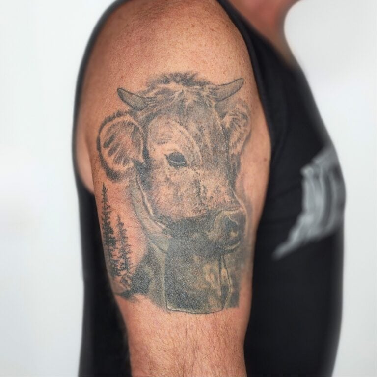 Verblasstes Kuh Tattoo am Oberarm – vor dem professionellen Touch-Up im Bastelbude Tattoo Studio Widnau.