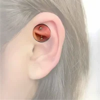 Ein Rook-Piercing, kunstvoll platziert in der Ohrfalte oberhalb des Tragus, verziert mit einem kleinen, stilvollen Ring, der einen Hauch von Eleganz und Individualität verleiht.