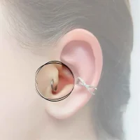 Detailansicht eines Tragus-Piercings, platziert am vorderen Knorpel nahe der Ohröffnung, geschmückt mit einem kleinen, glitzernden Stud für einen subtilen, modischen Akzent.