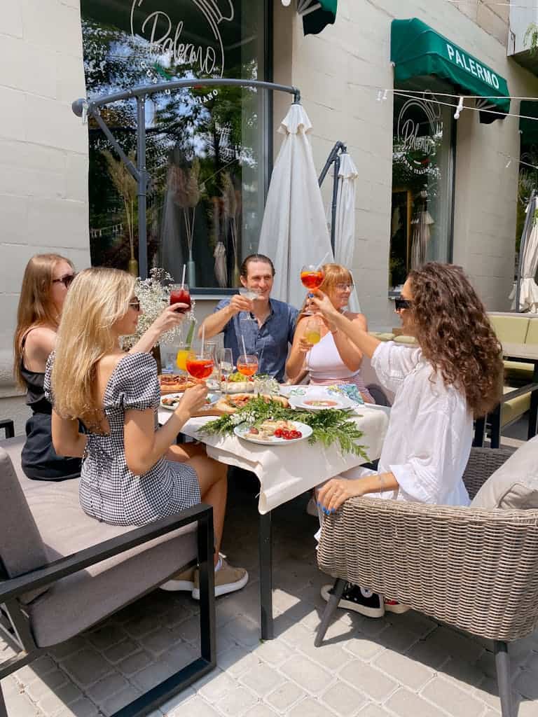People Sitting at Table with Food and Drinks