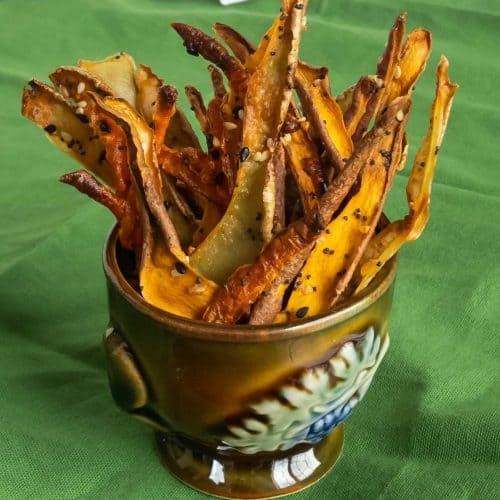 Vegetable skin crisps standing upright in a small cup