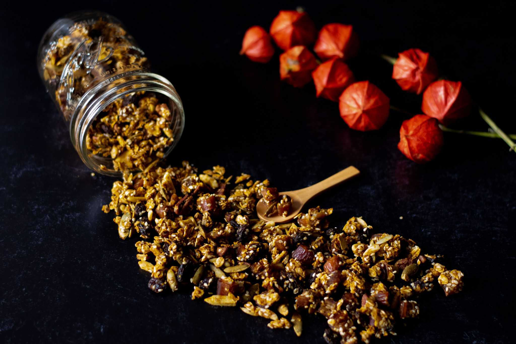 Pumpkin Granola spilling out of a glass jar