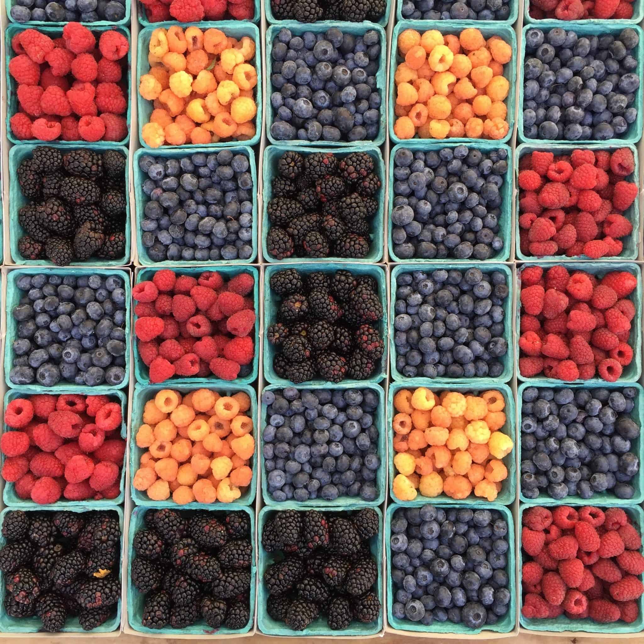Different colored berries in pint boxes, from overhead