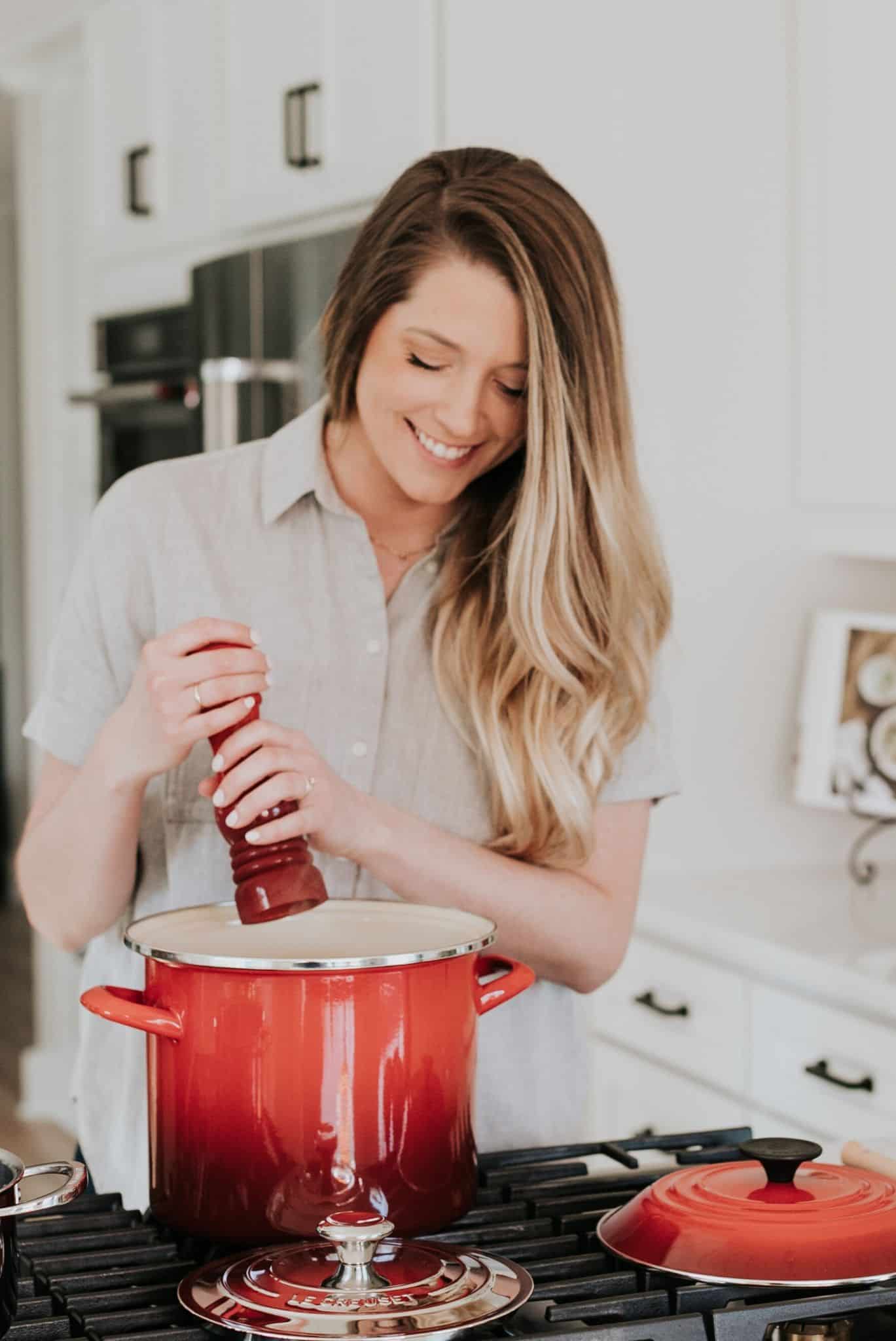 Woman adding salt to a pot on the stove