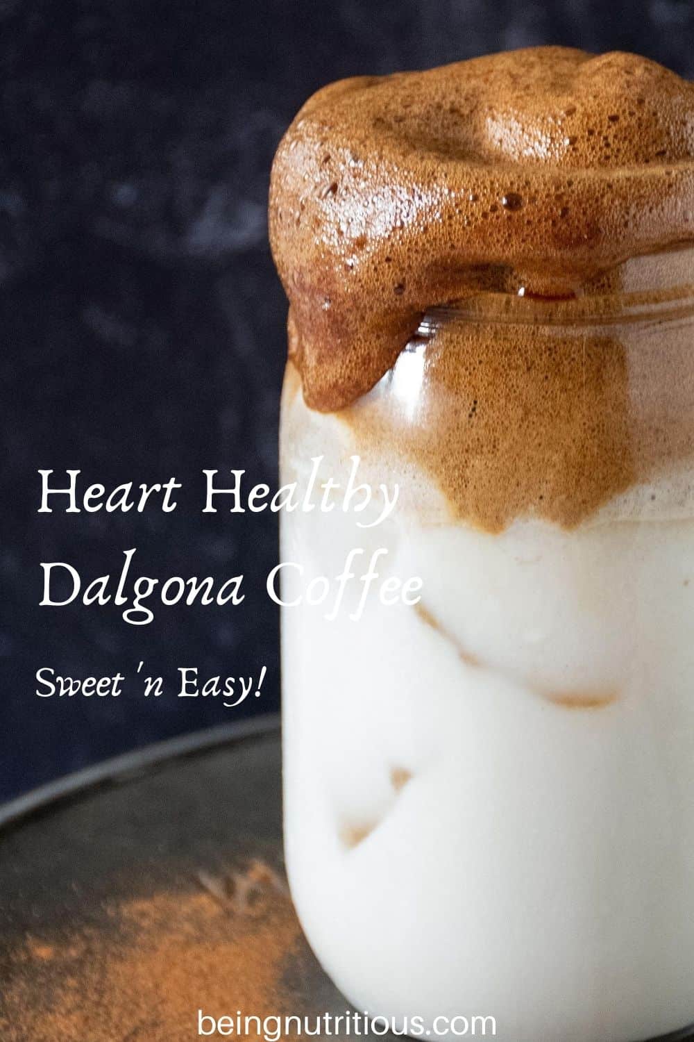 Close up of whipped coffee over iced almond milk in a Mason jar with text overlay: "Heart Healthy Dalgona Coffee, sweet 'n easy"