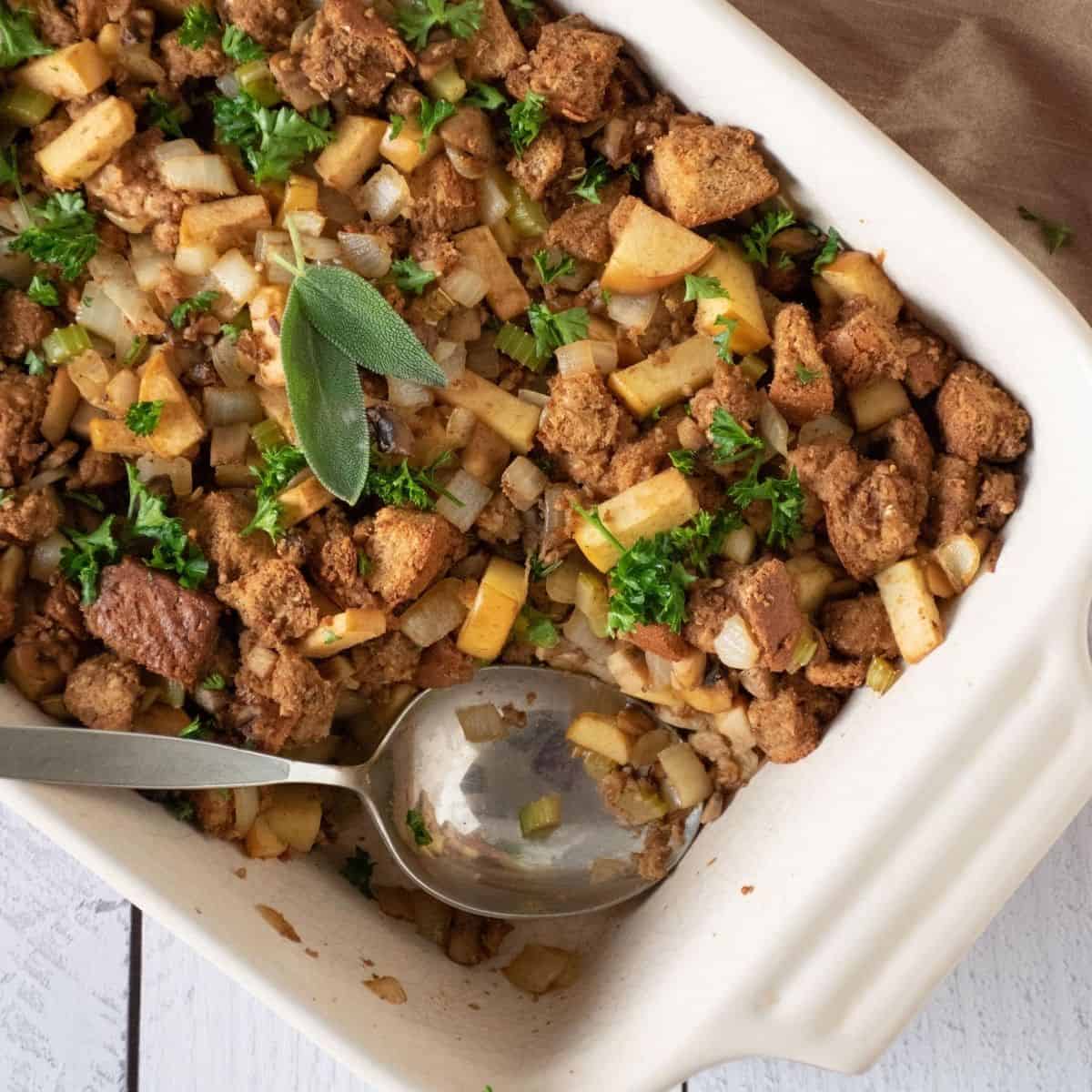Large casserole dish with stuffing, and a spoon.