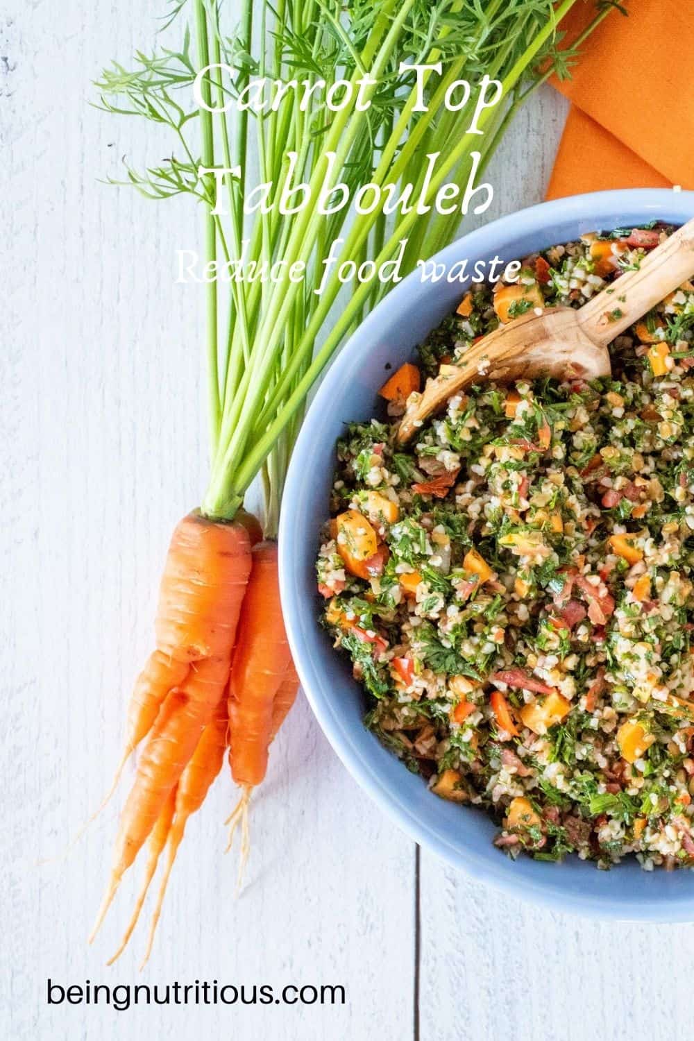 Overhead shot of carrot greens salad in a blue bowl, half of the bowl shown, with a bunch of carrots with the tops still attached lying beside the bowl. Text overlay: Carrot Top Tabbouleh; Reduce food waste.