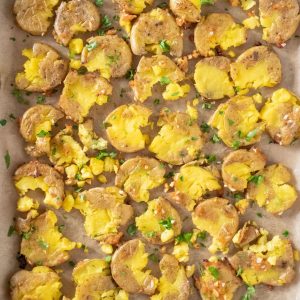 Overhead picture of smashed potatoes on a baking sheet.