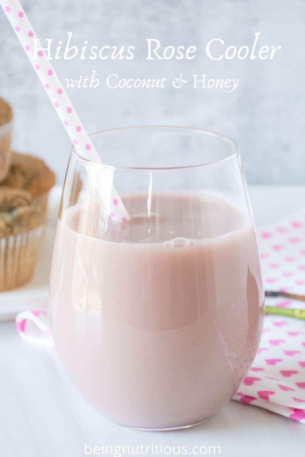 Glass of pink beverage. Text overlay: Hibiscus Rose Cooler with Coconut & Honey.