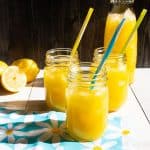 Three Mason jars with lemonade in them.