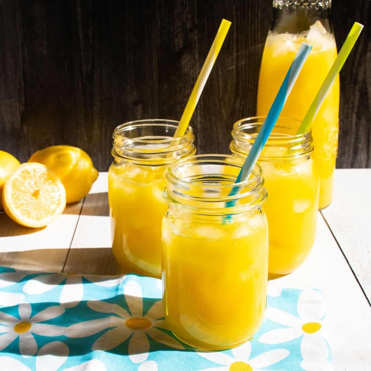 Three Mason jars with lemonade in them.