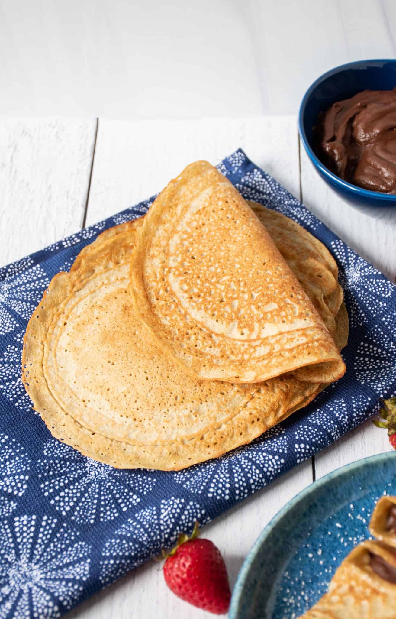 Pile of crepes made from chickpea flour on a blue napkin