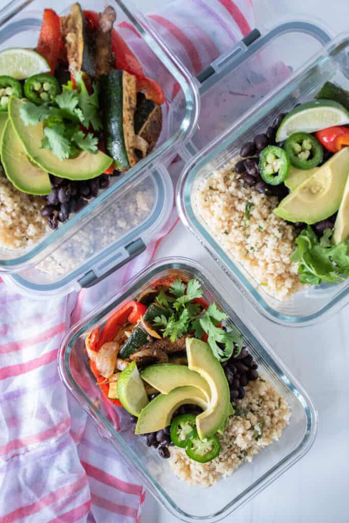 5 glass meal prep containers filled with burrito fillings.