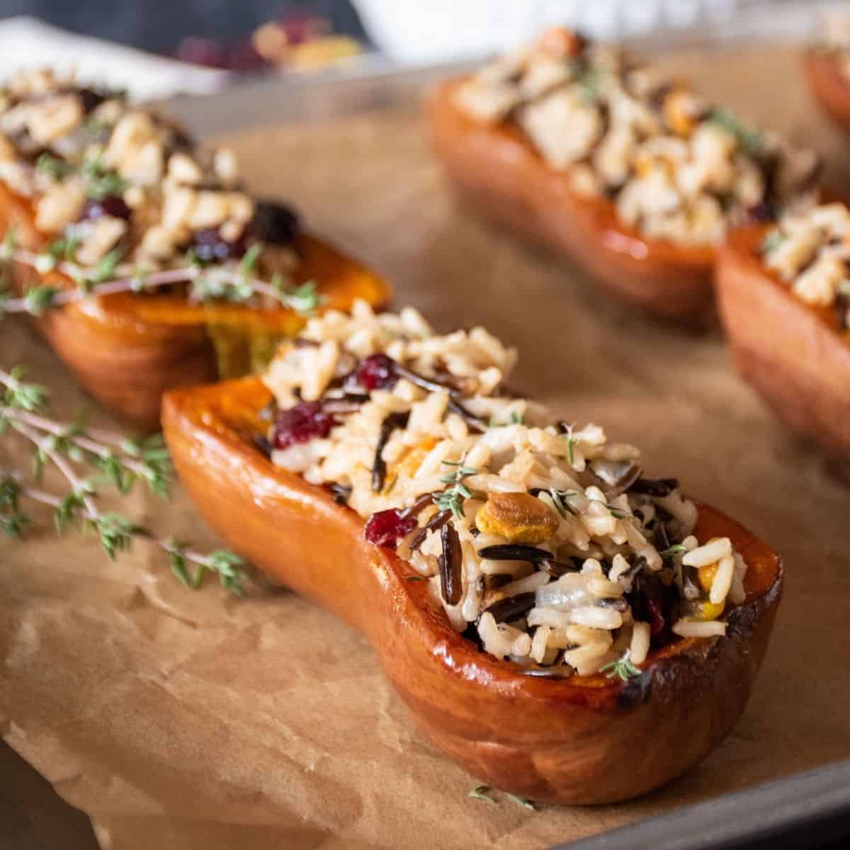 Stuffed honeynut squash halves on a baking pan.