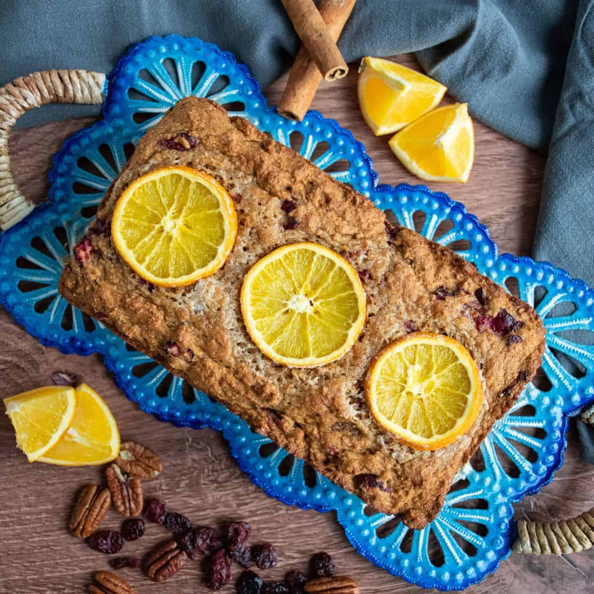 Overhead shot of a loaf of quick bread studded with candied oranges.